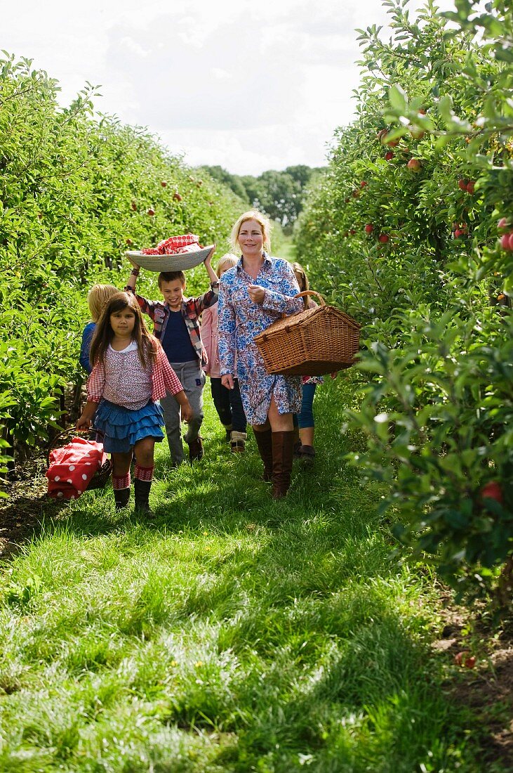 A mother and children in an apple orchard