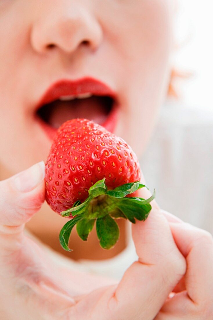 Woman eating a strawberry