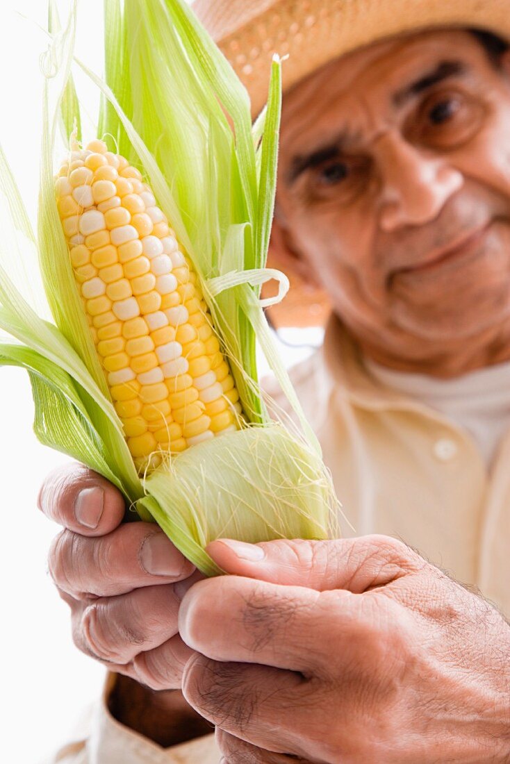 Man holding a corn on the cob