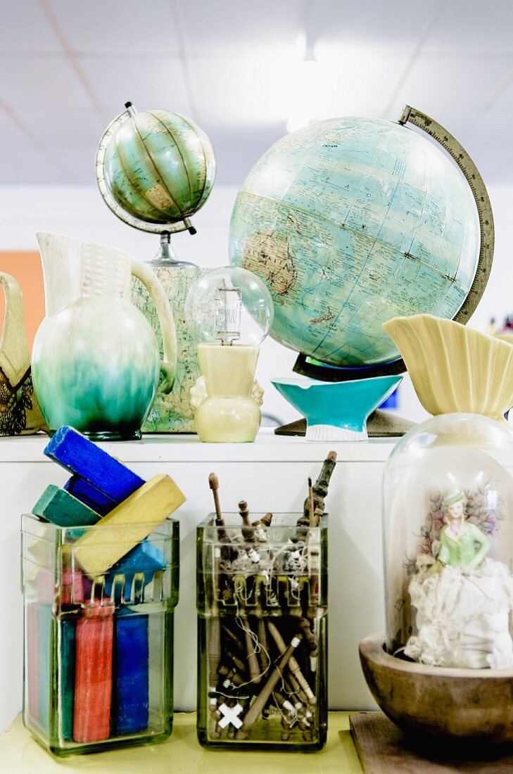 Storage jar of building blocks and various collectors' items and ornaments on surfaces