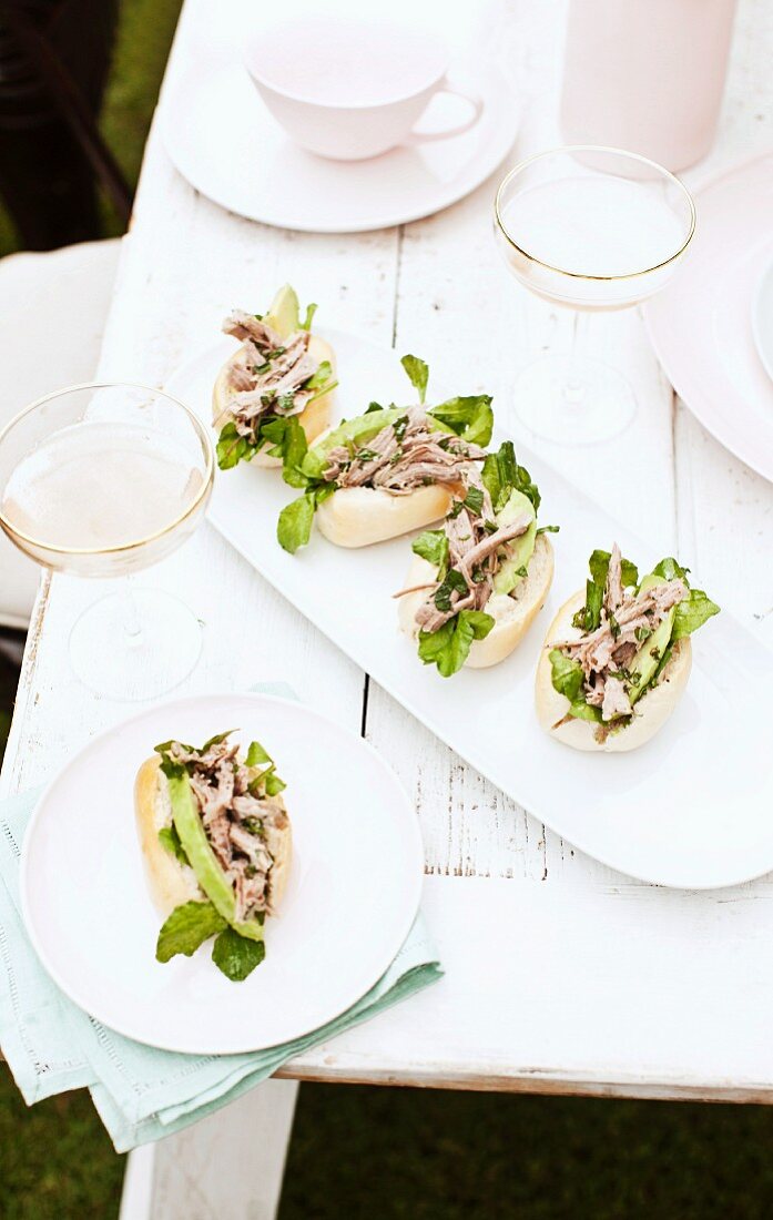 Bread rolls filled with lamb, avocado and mint, on a table outdoors