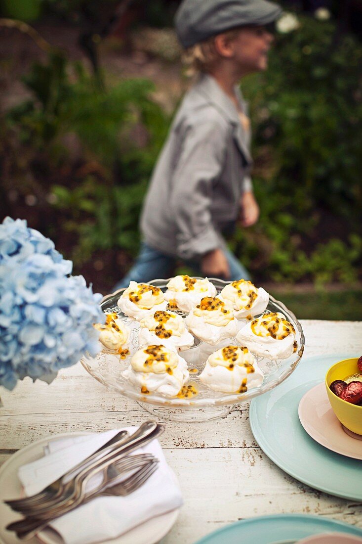 Meringue mit Passionsfruchtcreme auf Tisch im Freien