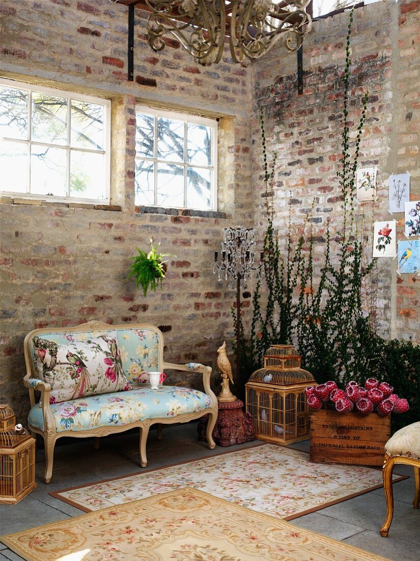 Vintage rugs in front of Rococo bench in corner of loft-style interior with brick walls