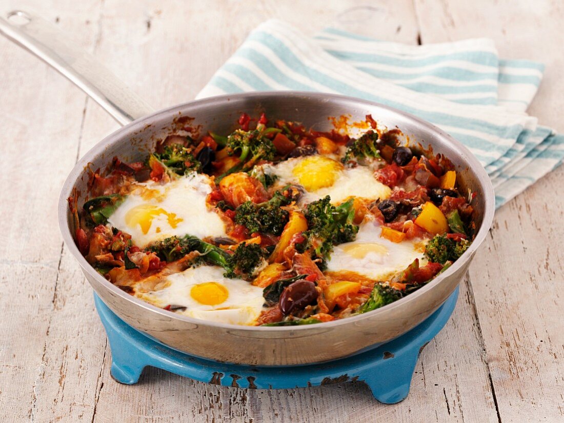 Fried eggs with broccoli and pepper in a pan