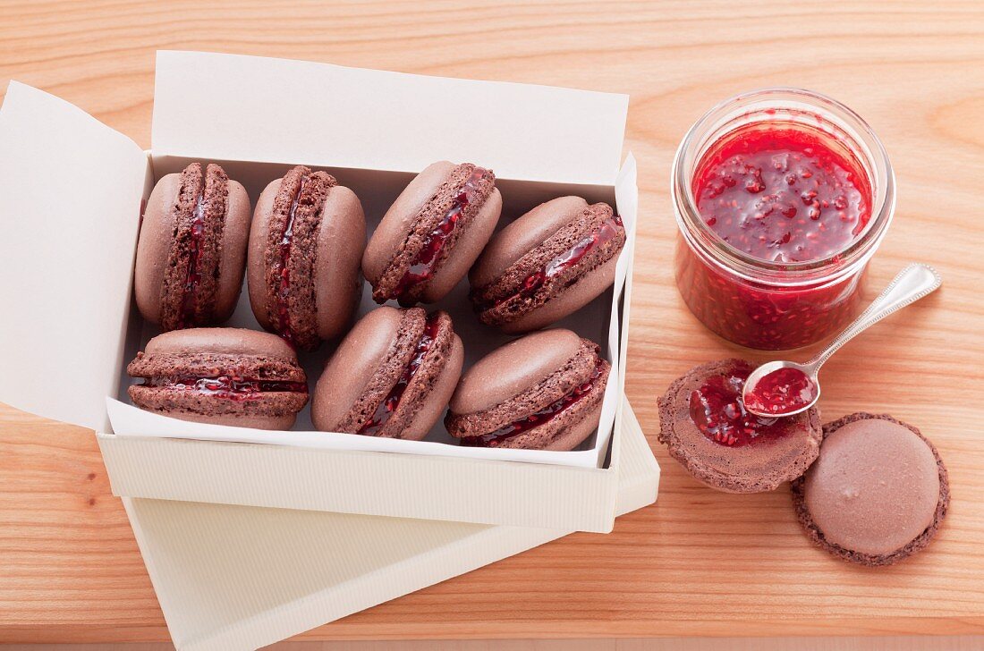 Schokoladen-Macarons mit Himbeermarmelade gefüllt in einer weißen Schachtel