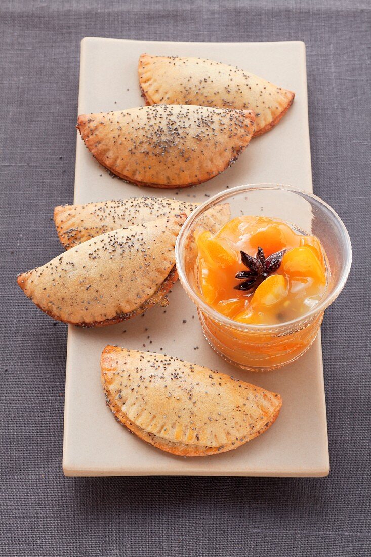 Süße Mohn-Piroggen mit Orangen-Dip auf länglicher Platte