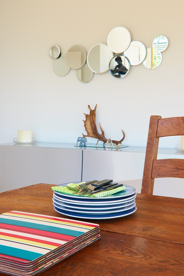 Stacked plates and boards on solid wooden dining table