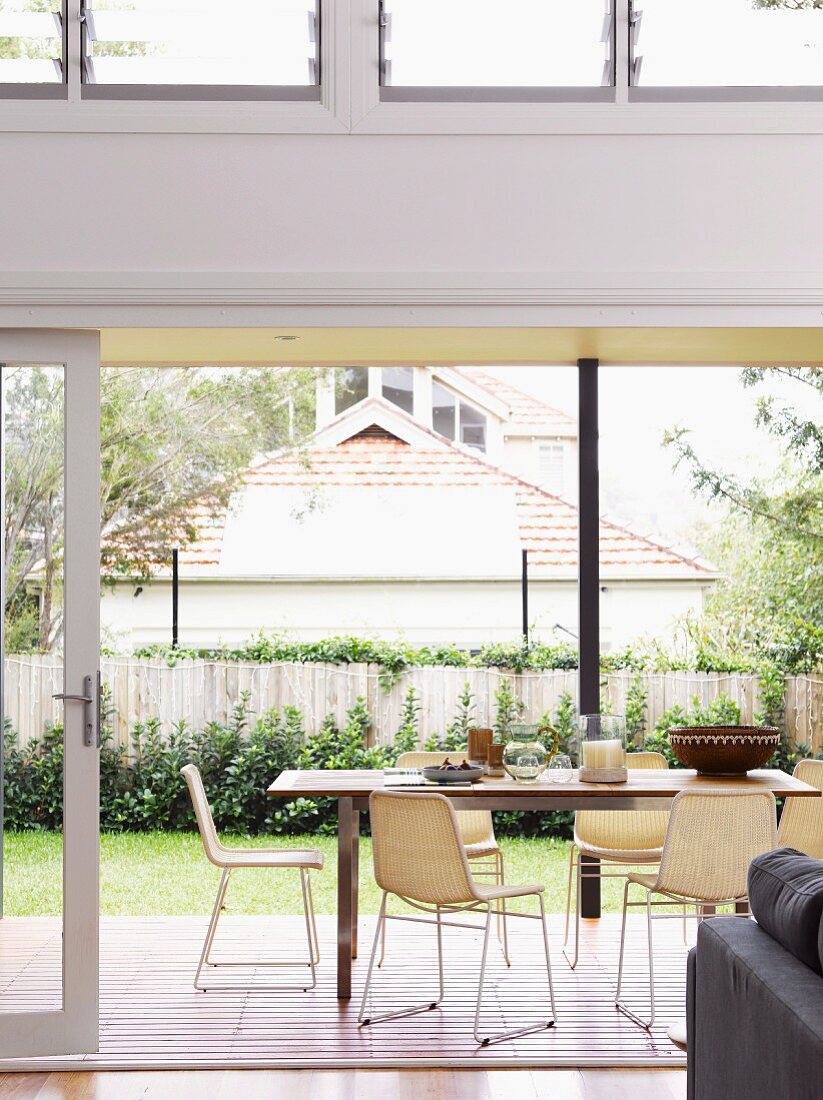 View of seating area on terrace of architect-designed house with garden and view of neighbouring building