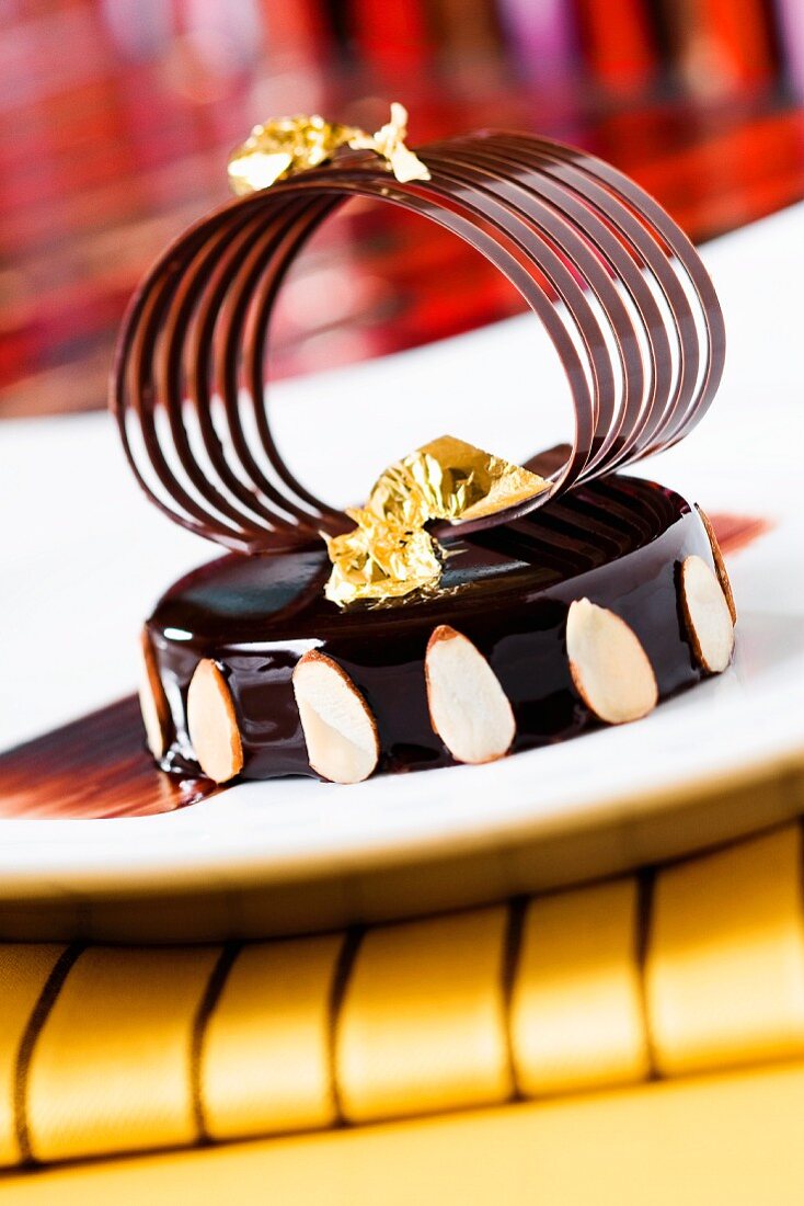 Chocolate Cake with Sliced Almonds, Gold Foil, and a Chocolate Garnish