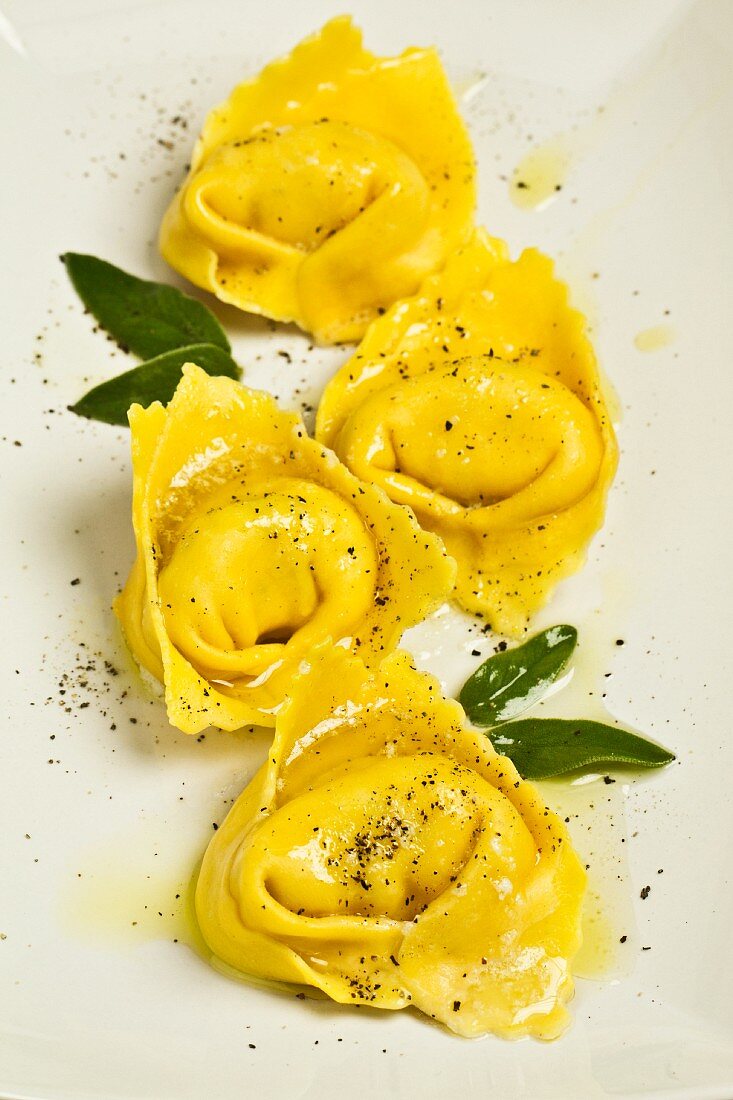 Four tortellinis with sage leaves