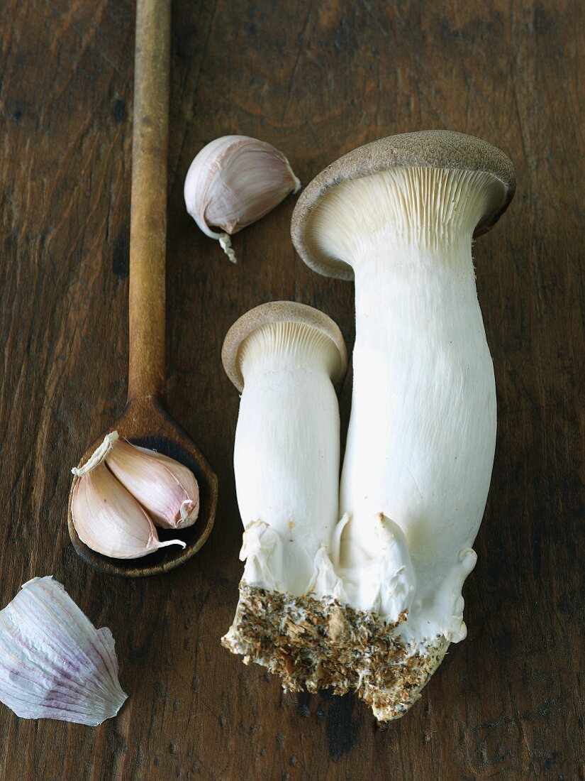 Kräutersaitlinge und Knoblauch auf einem Schneidebrett