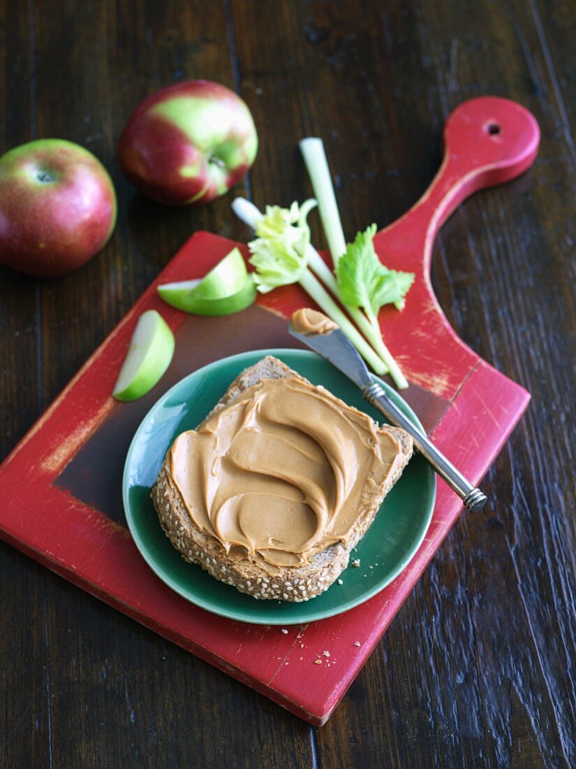 Peanut Butter on a Slice of Whole Wheat Bread with Apples and Celery