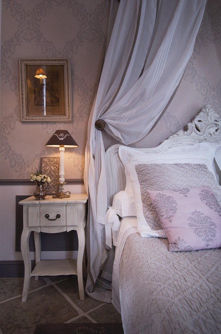 Fürstliches Bett mit grau-weisser Bettwäsche und Zierkissen Ton in Ton mit der Wandtapete