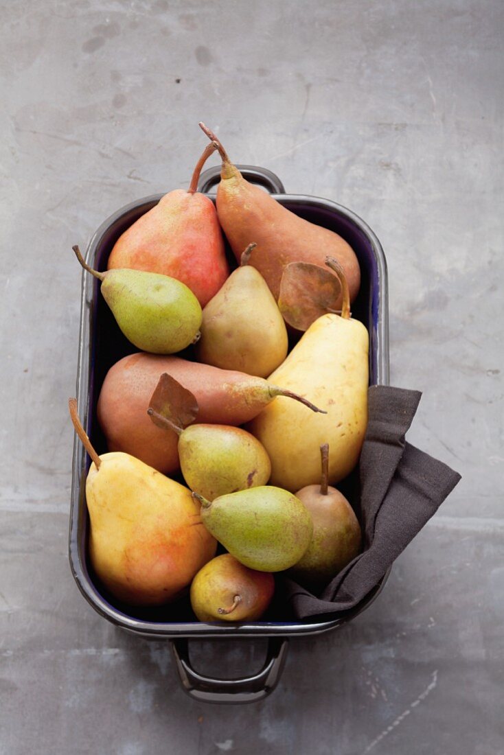 Assorted varieties of pear in a roasting tin