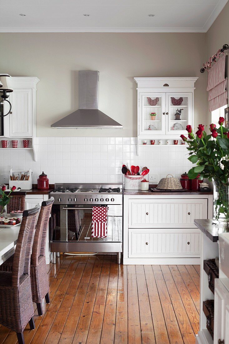 Dining area in white country-house kitchen with wooden floor