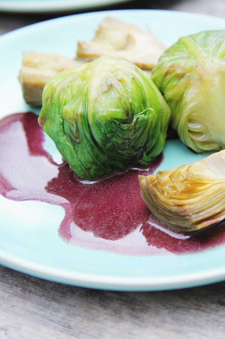 Jakobsmuscheln in blanchiertem Kopfsalat mit Artischocken und Zwiebel-Rotwein-Sauce