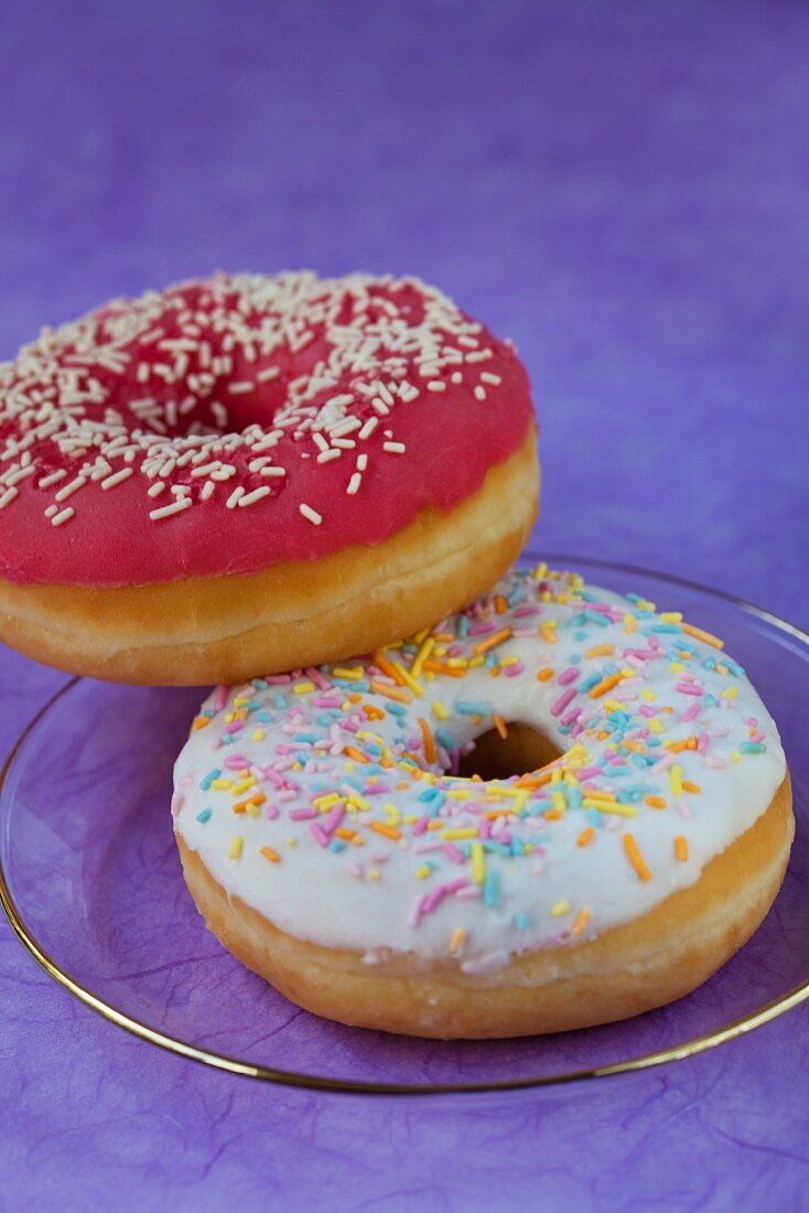 Two doughnuts with glaze and sugar sprinkles