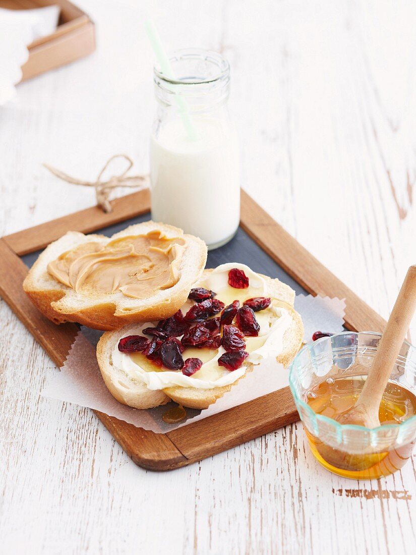 White bread topped with honey and cranberries and peanut butter