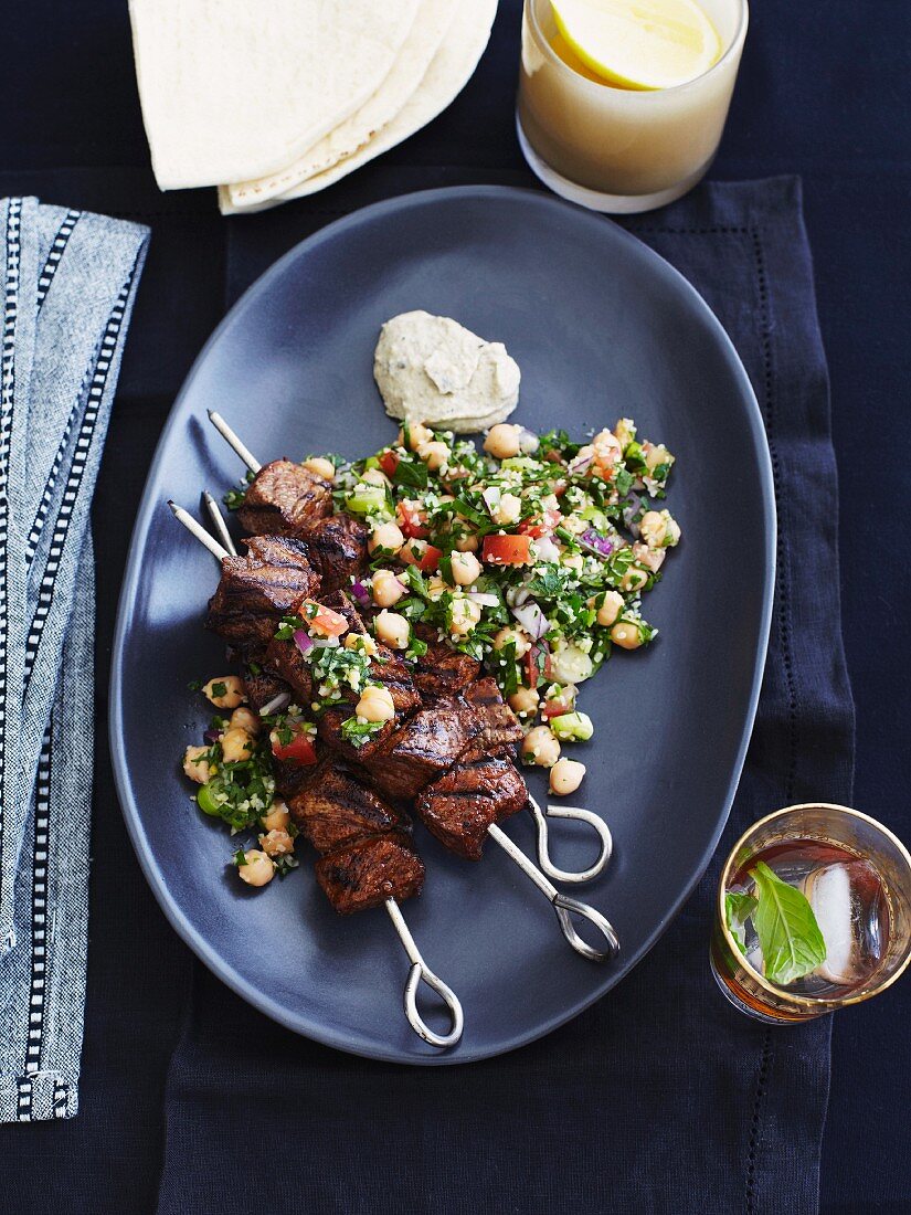 Grilled beef kebabs on a bed of chickpea tabbouleh