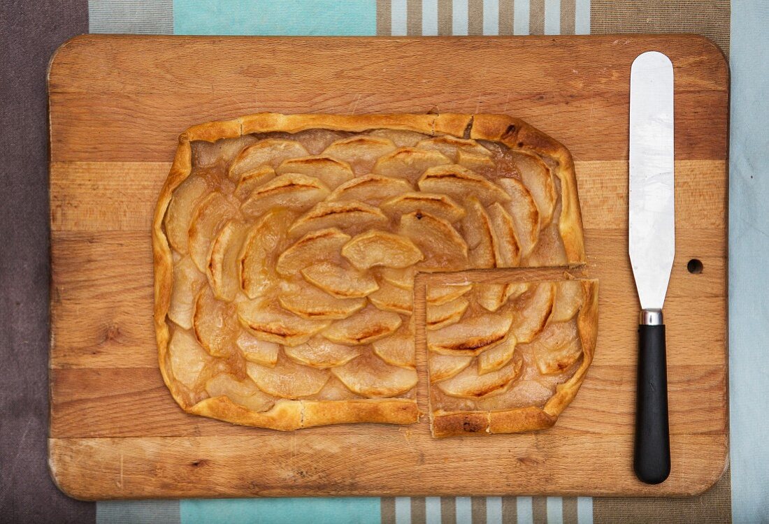 Apple tart, sliced on a chopping board