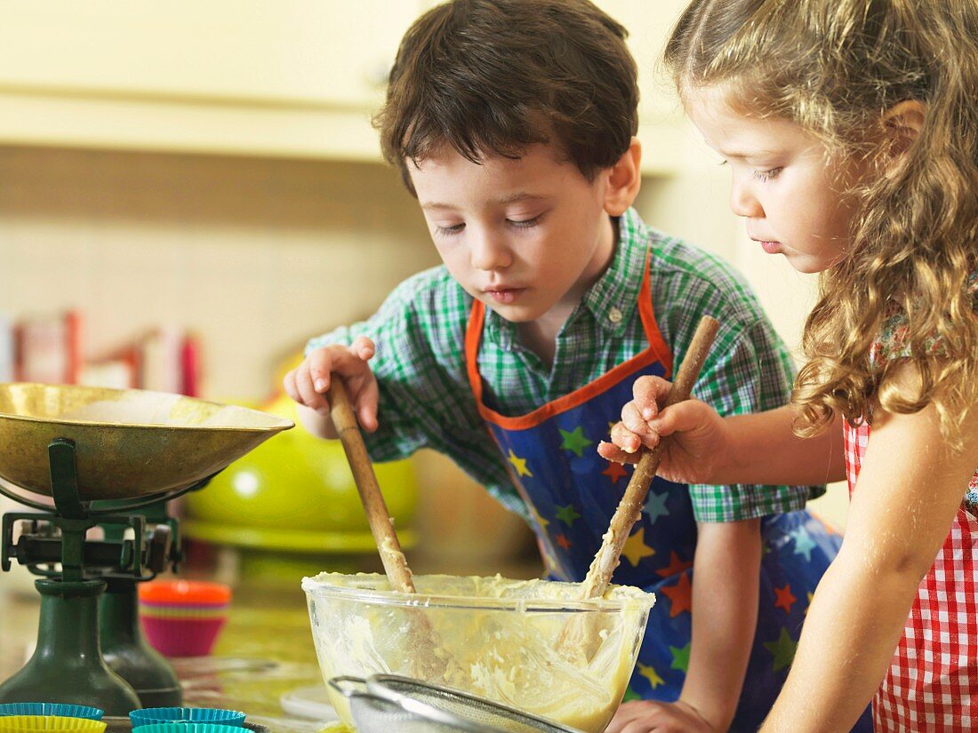 Children stirring a bowl of cake mixture