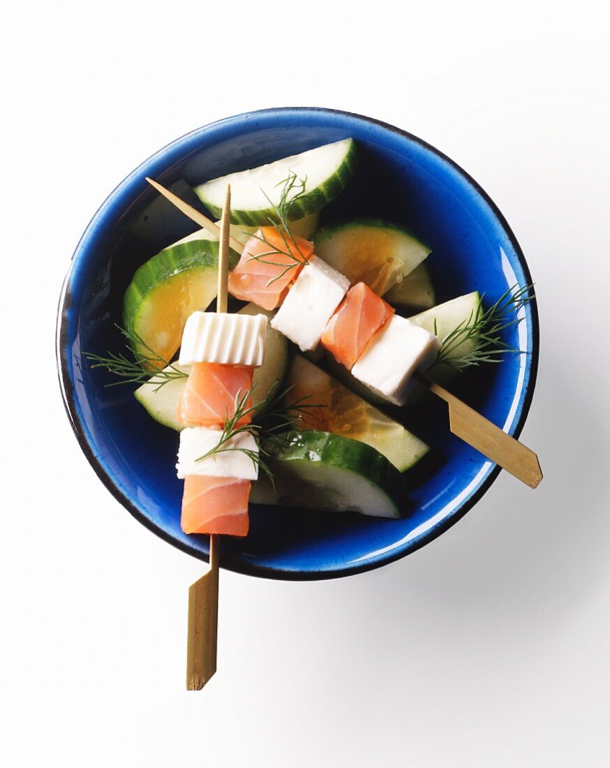 Salmon and feta kebabs on a bed of cucumber slices