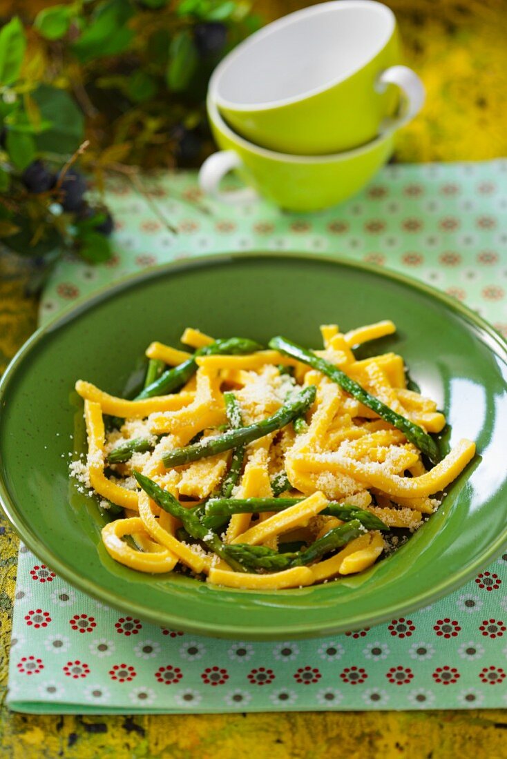 Corn noodles with asparagus on a green plate