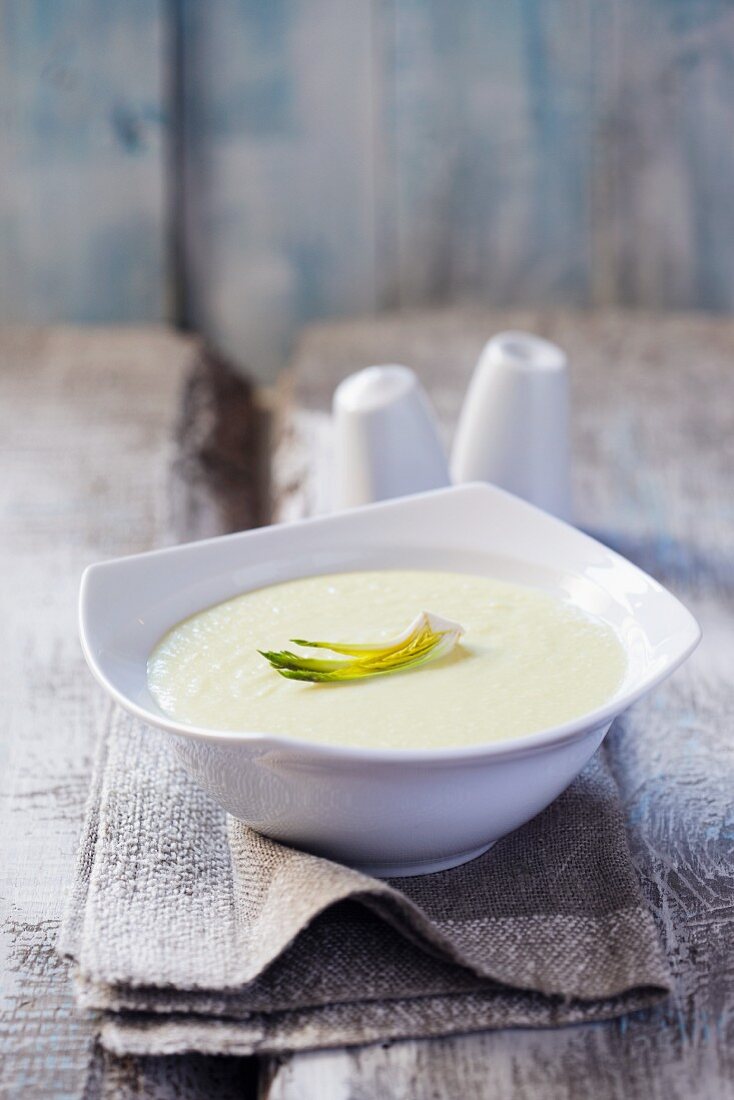 Cream horseradish soup in a white bowl on a grey napkin