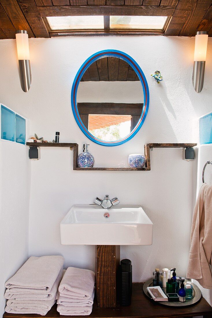 Rustic washstand and oval mirror in bathroom