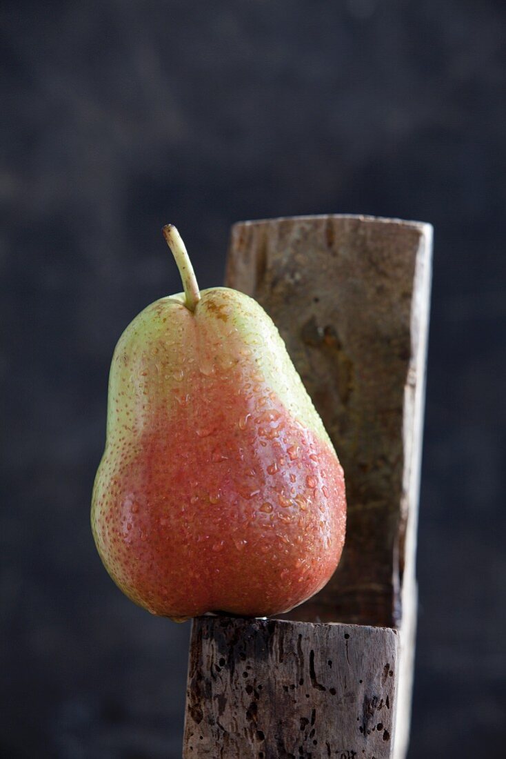 A wet pear on a wooden surface