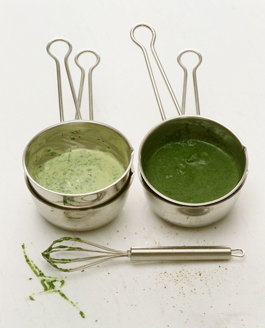 Green herb sauce in saucepans