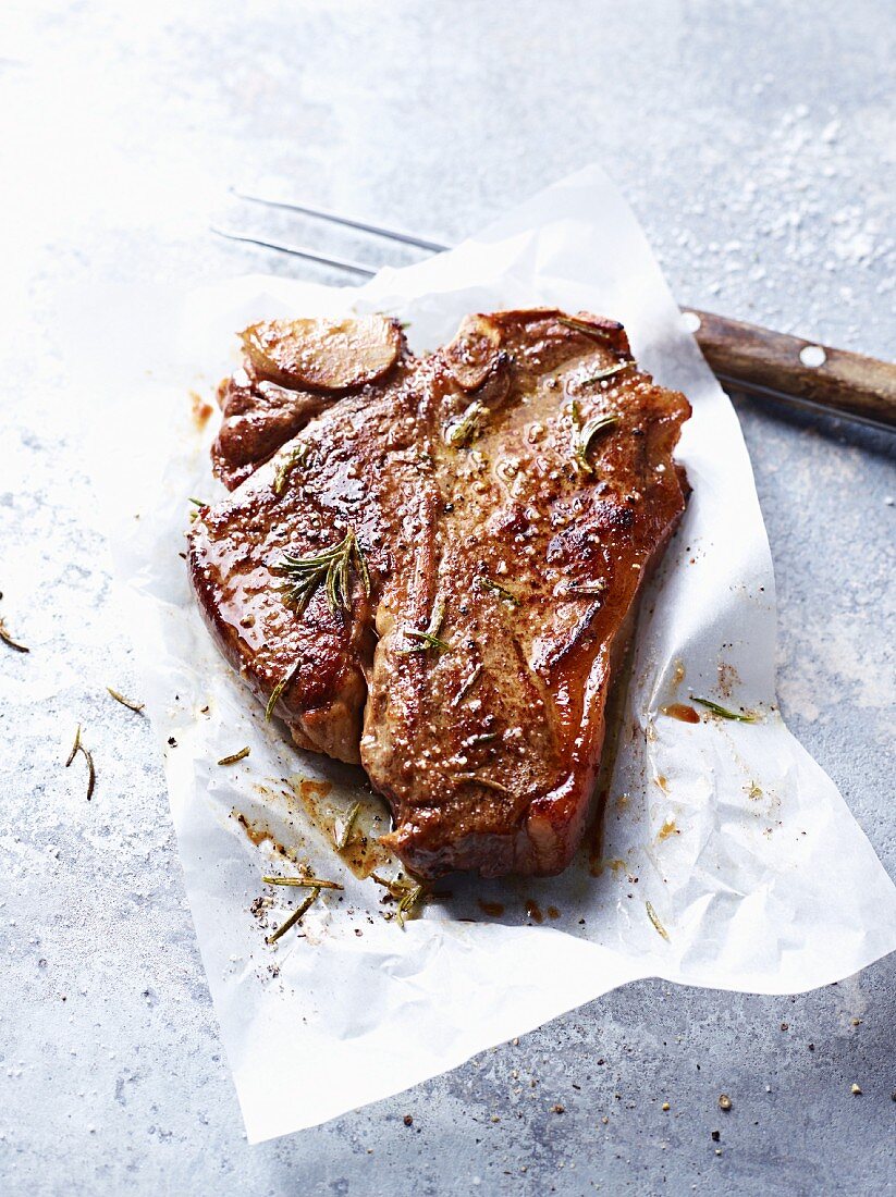 A T-bone steak with rosemary
