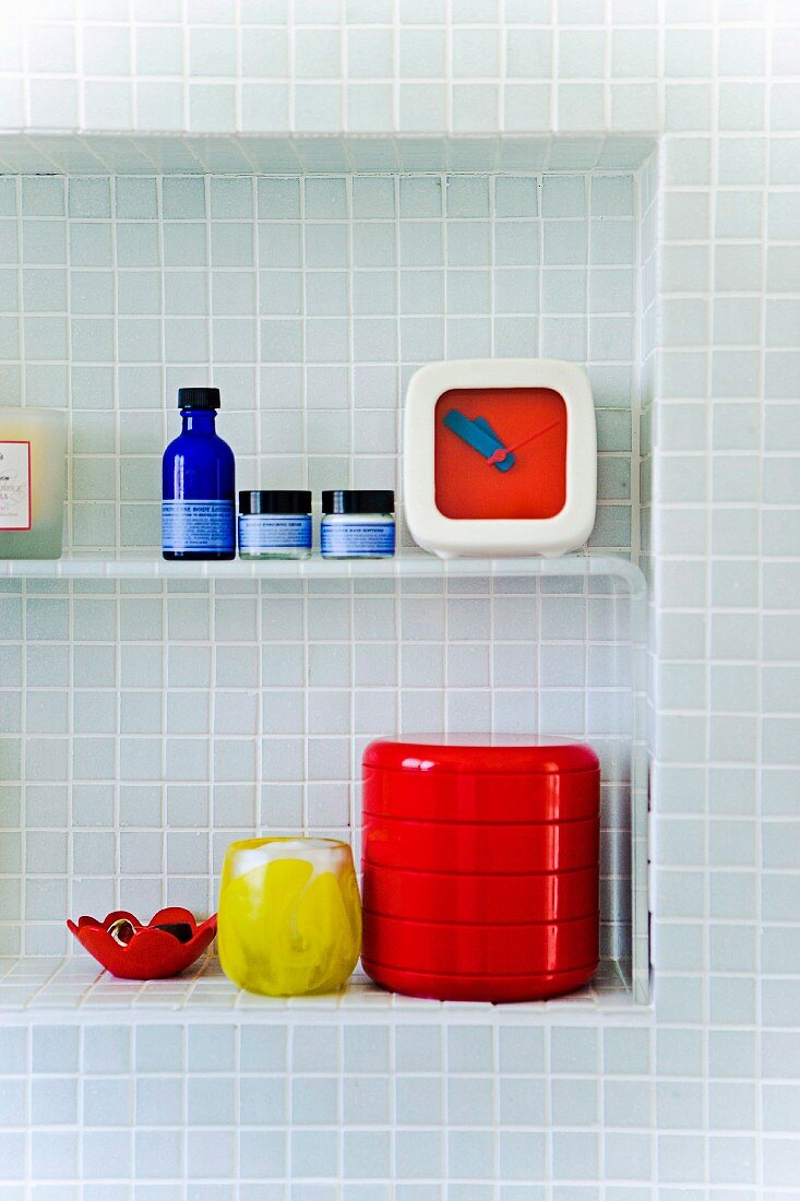 Bathroom shelf in alcove; pastel blue mosaic tiles on the wall