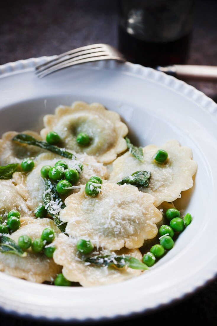 Raviolis with Peas and Parmesan Cheese in a White Bowl