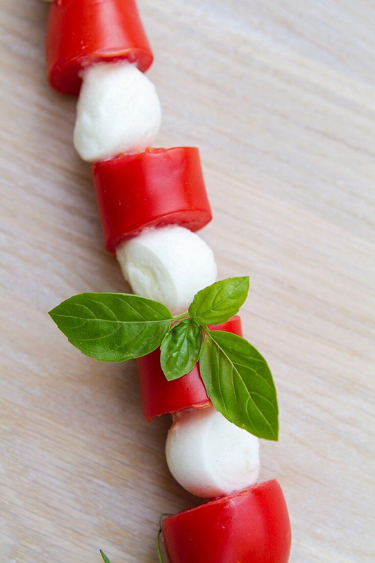 A tomato and mozzarella kebab with basil