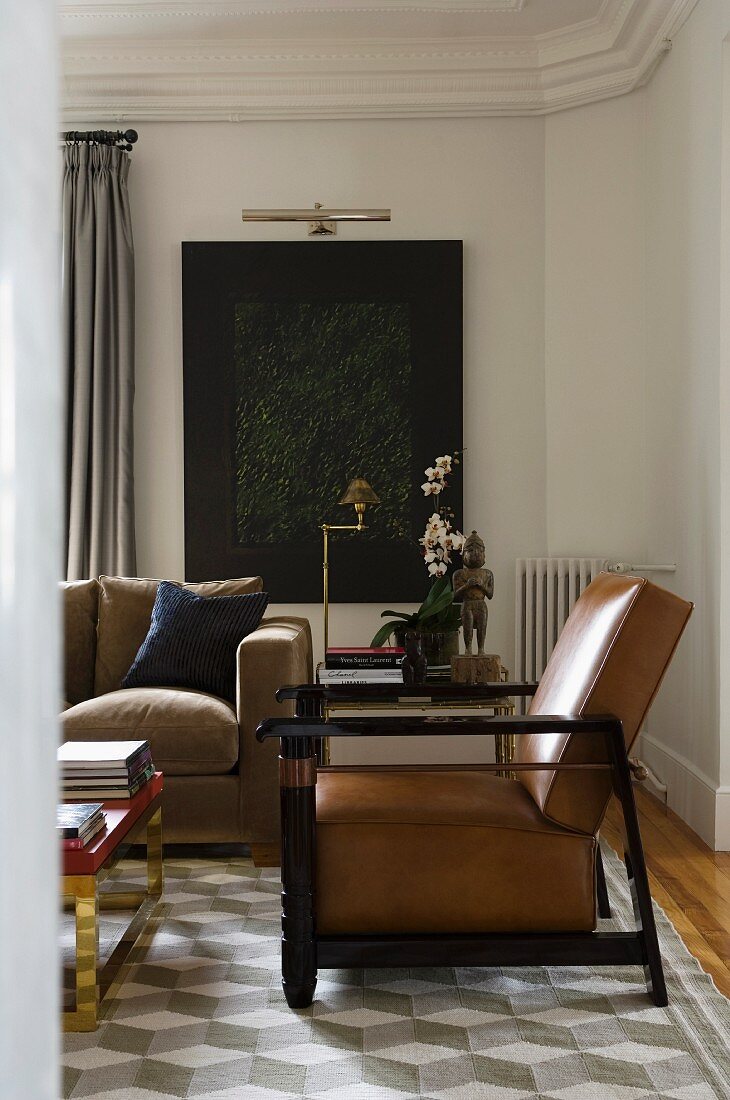 Eleganter Sessel im Art Deko Stil und teilweise sichtbare Couch auf Teppich mit dreidimensionalem Muster in herrschaftlicher Wohnzimmerecke