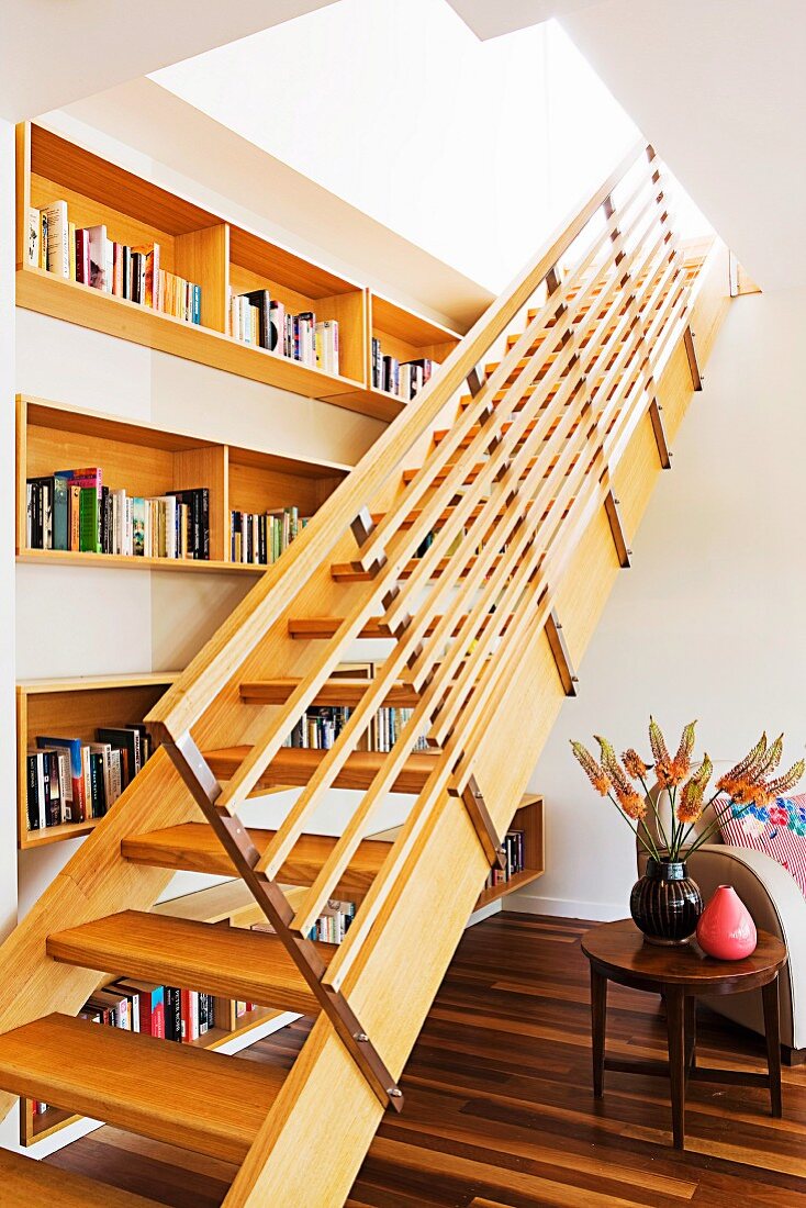 Modern interior with wooden staircase running through ceiling opening