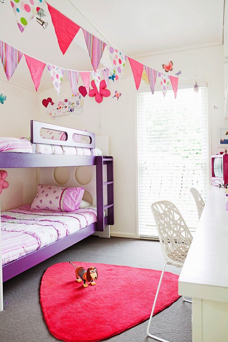Happy children's room with pennants and lots of color accents in purple and pink