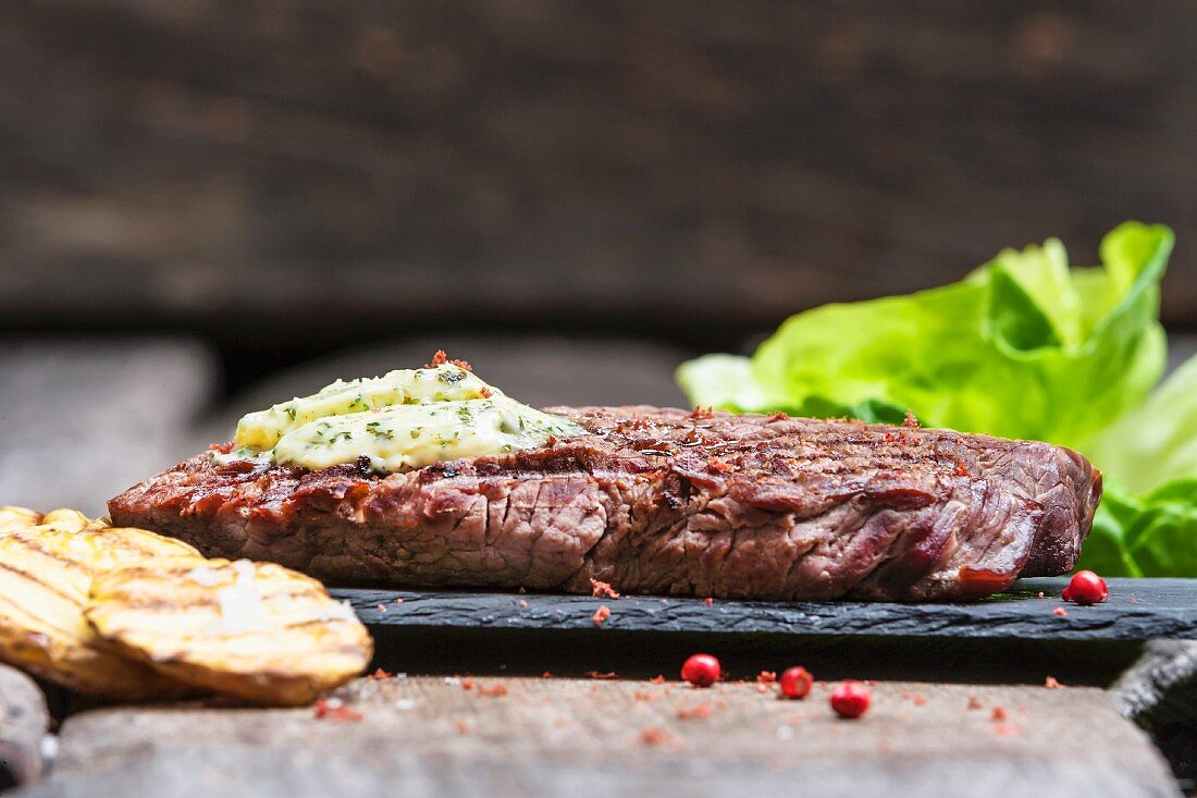 Beef steak with herb butter and pink pepper (close-up)