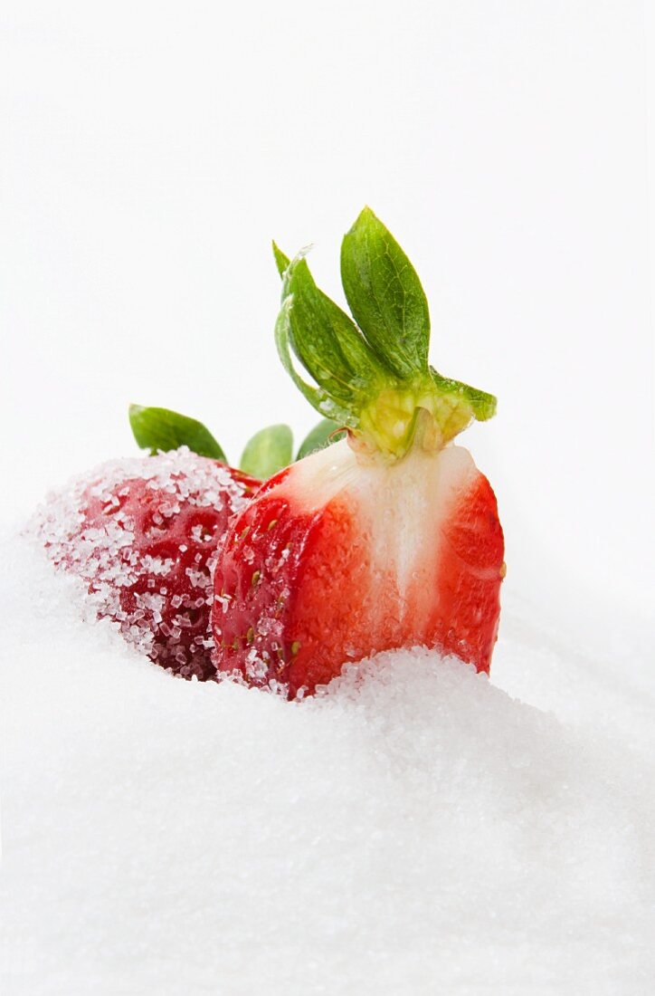 Half a strawberry in a pile of sugar