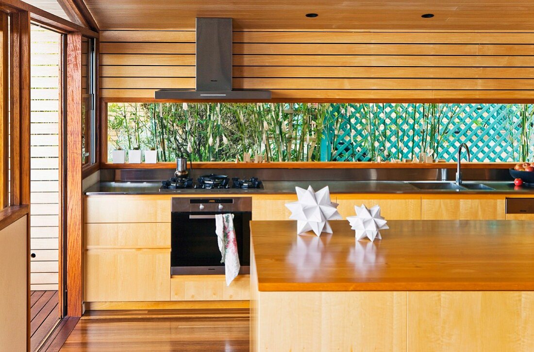 Island counter in front of kitchen counter with solid wood base units in residential house