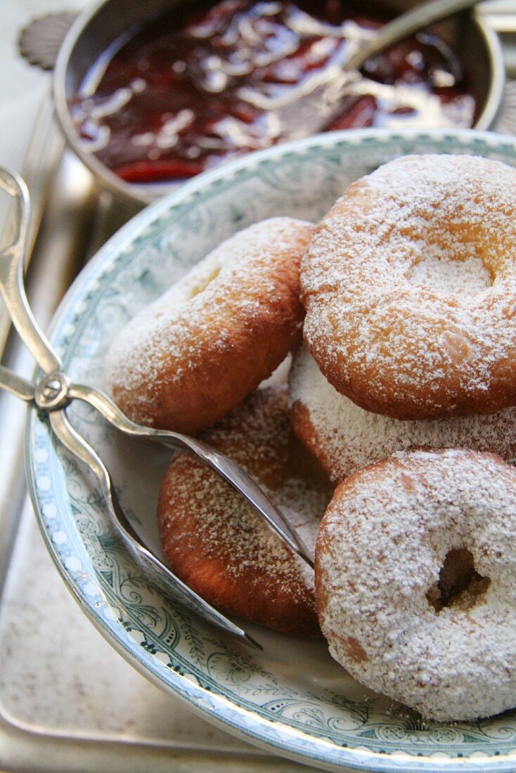 Ausgezogene (Bavarian-style doughnuts) in a light blue bowl with pastry tongs