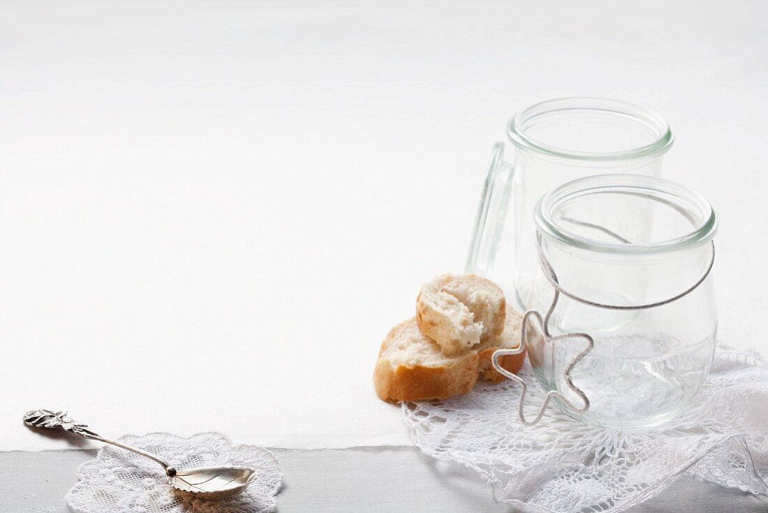 Empty jars and slices of baguette on a lace doily