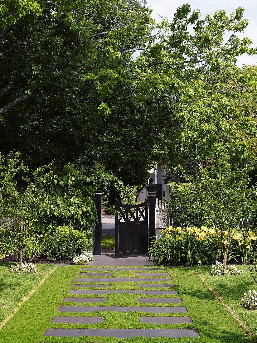 Front garden path of stone flags interspersed with lawn and Victorian-style front gate