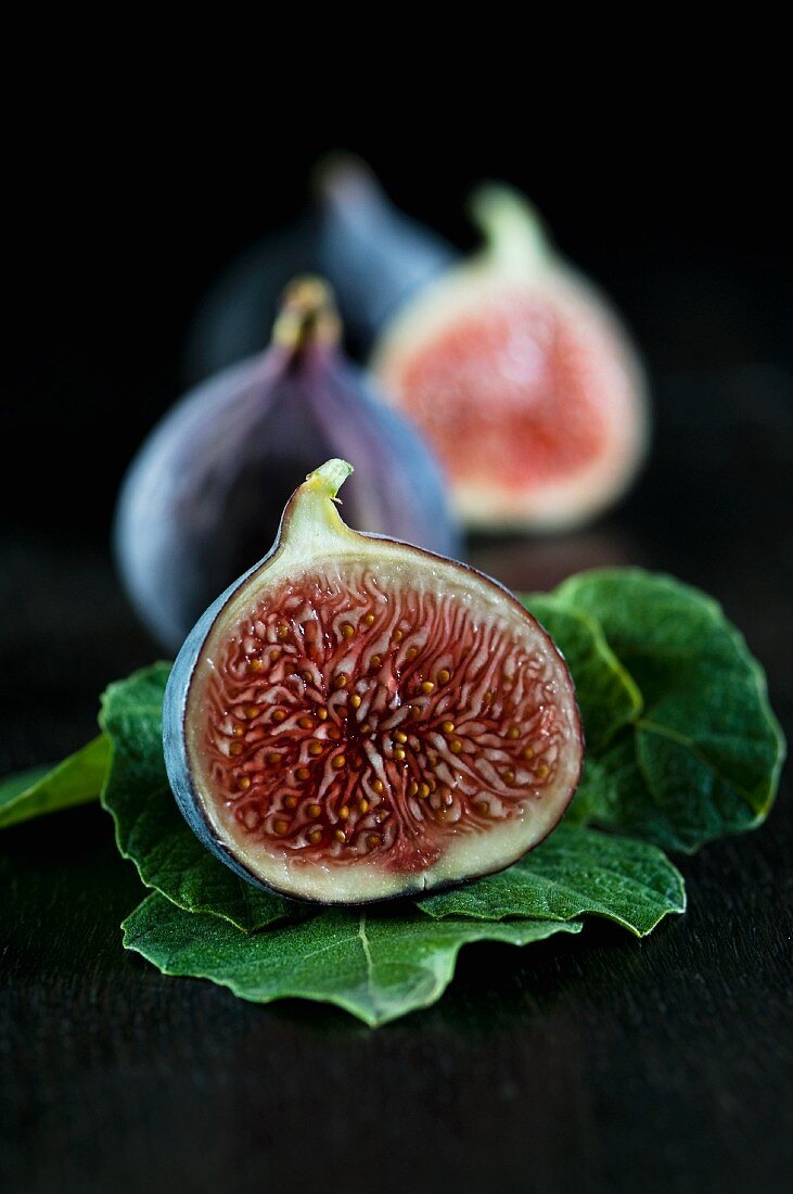 Fresh figs, whole and halved, and fig leaves