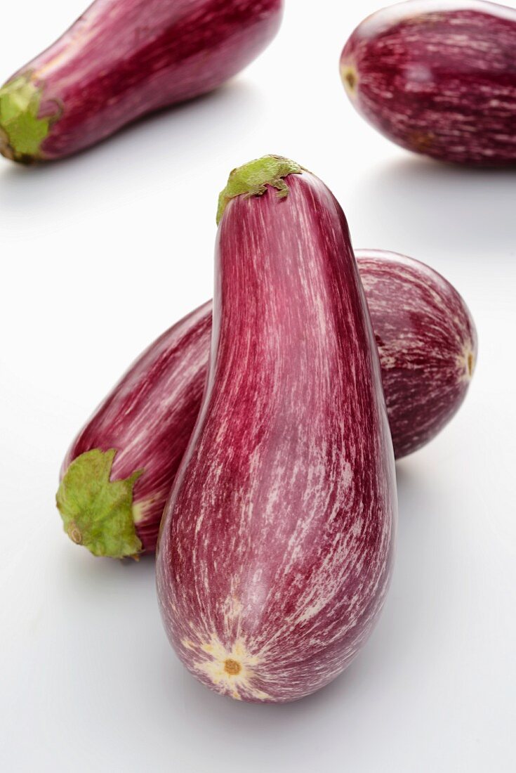 Aubergines on a white surface