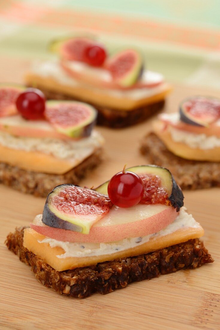 Wholemeal bread topped with melon, cheese, peach, figs and redcurrants