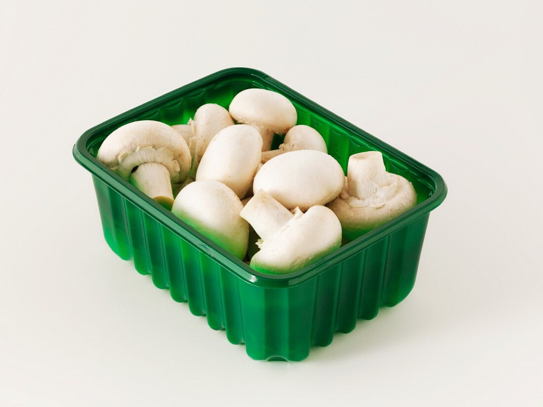 Fresh button mushrooms in a plastic punnet