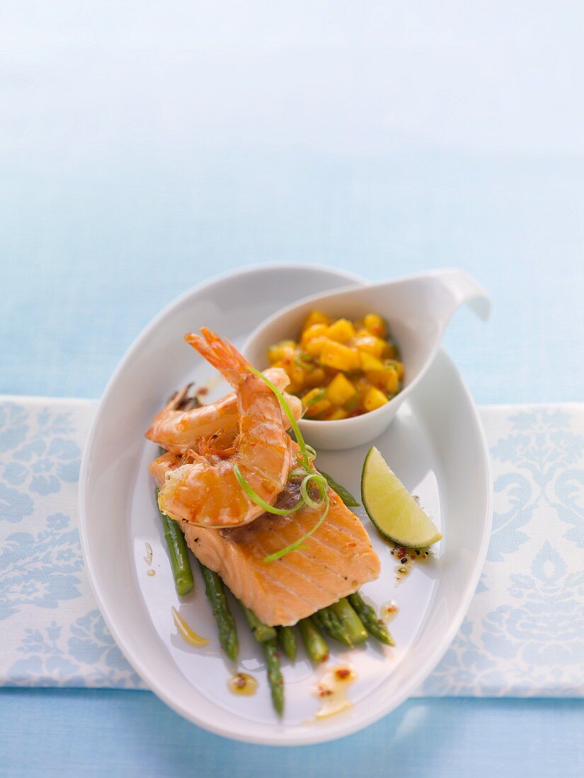 Fried salmon with prawns on a bed of asparagus with mango salsa