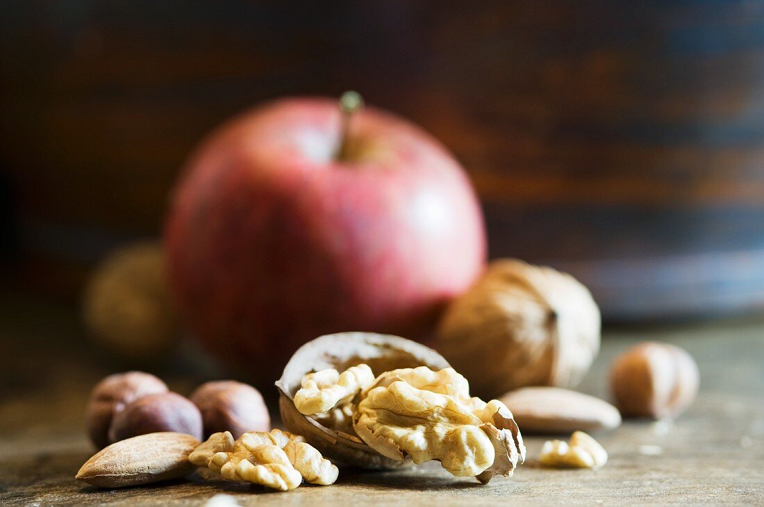 An arrangement of walnuts, nuts and an apple